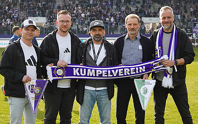 Verantwortliche vom SFV und FC Erzgebirge Aue mit einem Aue-Schal im Stadion.