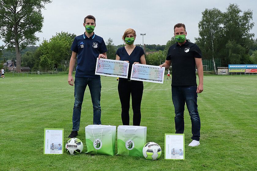 Übergabe unter Abstandsregeln: Christine Weigelt (Mitte) traf sich am Dienstag in Glauchau mit Eric Hofmann (Lok Glauchau, re.) und Matthias Schulz (Empor Glauchau, li.) um die beiden Vereine für die Solidaritätsgeste auszuzeichnen. © Matthias Winkelmann