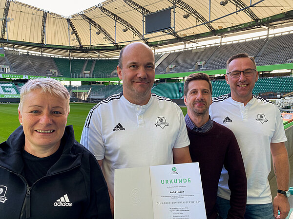 Heike Peschke (li.), André Mäbert, Tom Prager (Projektkoordinator) und Heiko März zum Gruppenbild in der Volkswagen-Arena in Wolfsburg.
