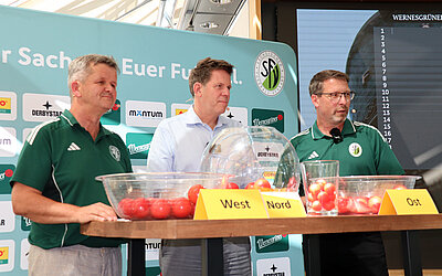 Björn Steigert (Mitte) als Geschäftsführer von der DDV-Mediengruppe war nicht nur "Losfee", sondern hatte auch zu verkünden, dass die SZ/LVZ in der nächsten Saison die Spiele des Wernesgrüner Sachsenpokals übertragen. Jens Breidel (Vorsitzender Spielausschuss) und Volkmar Beier (SFV-Vizepräsident) überwachten die Auslosung. © SFV/Verena Gladisch