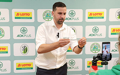 Tony Staigys von der AOK PLUS hat seine Aufgabe als Losfee mit Bravour gemeistert. © SFV